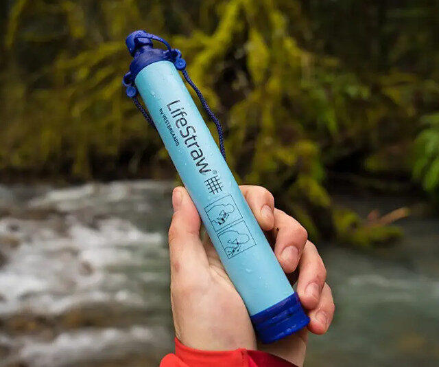 LIFE STRAW water filter held above a stream in nature